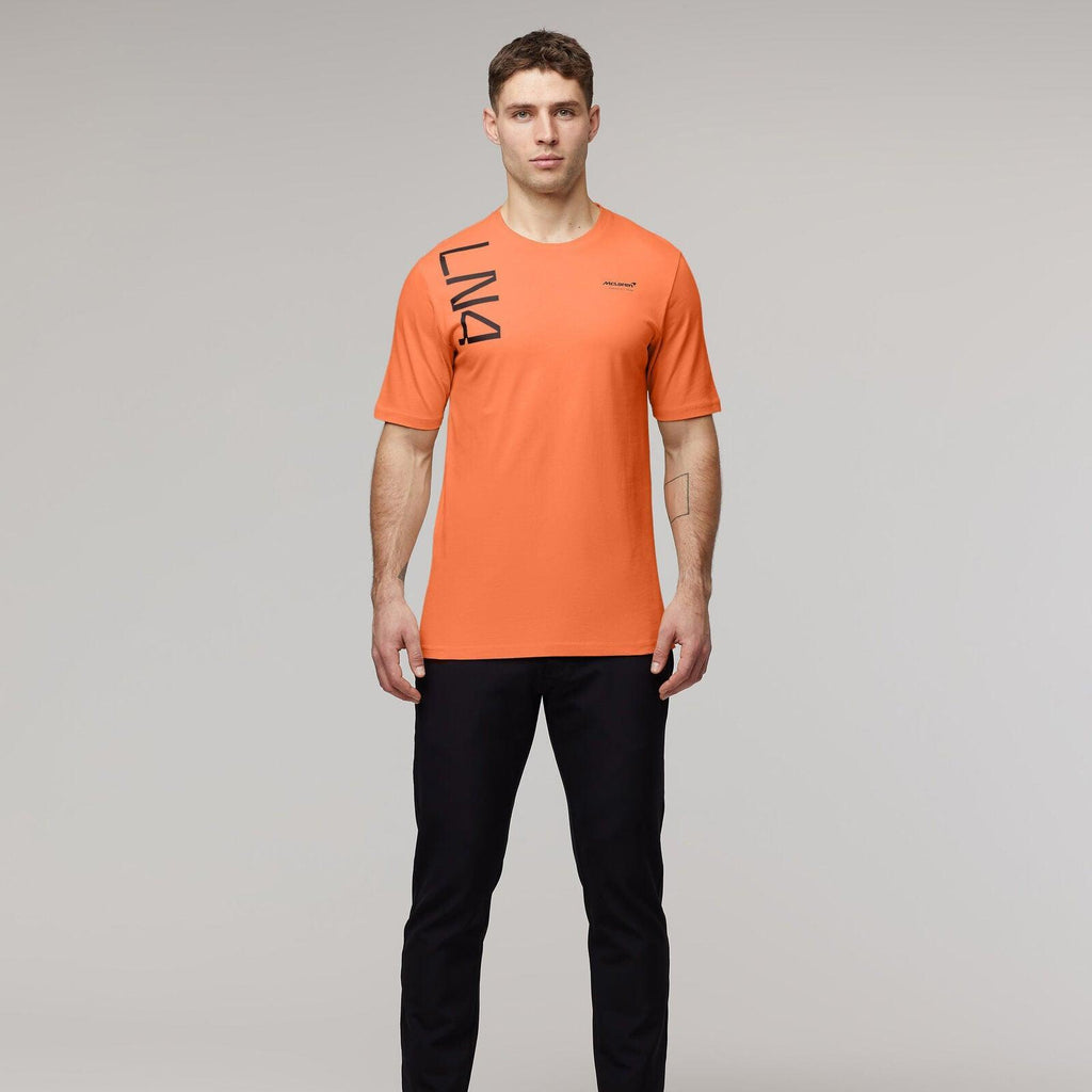 Man wearing an orange McLaren F1 Lando Norris Core T-shirt and black pants.
