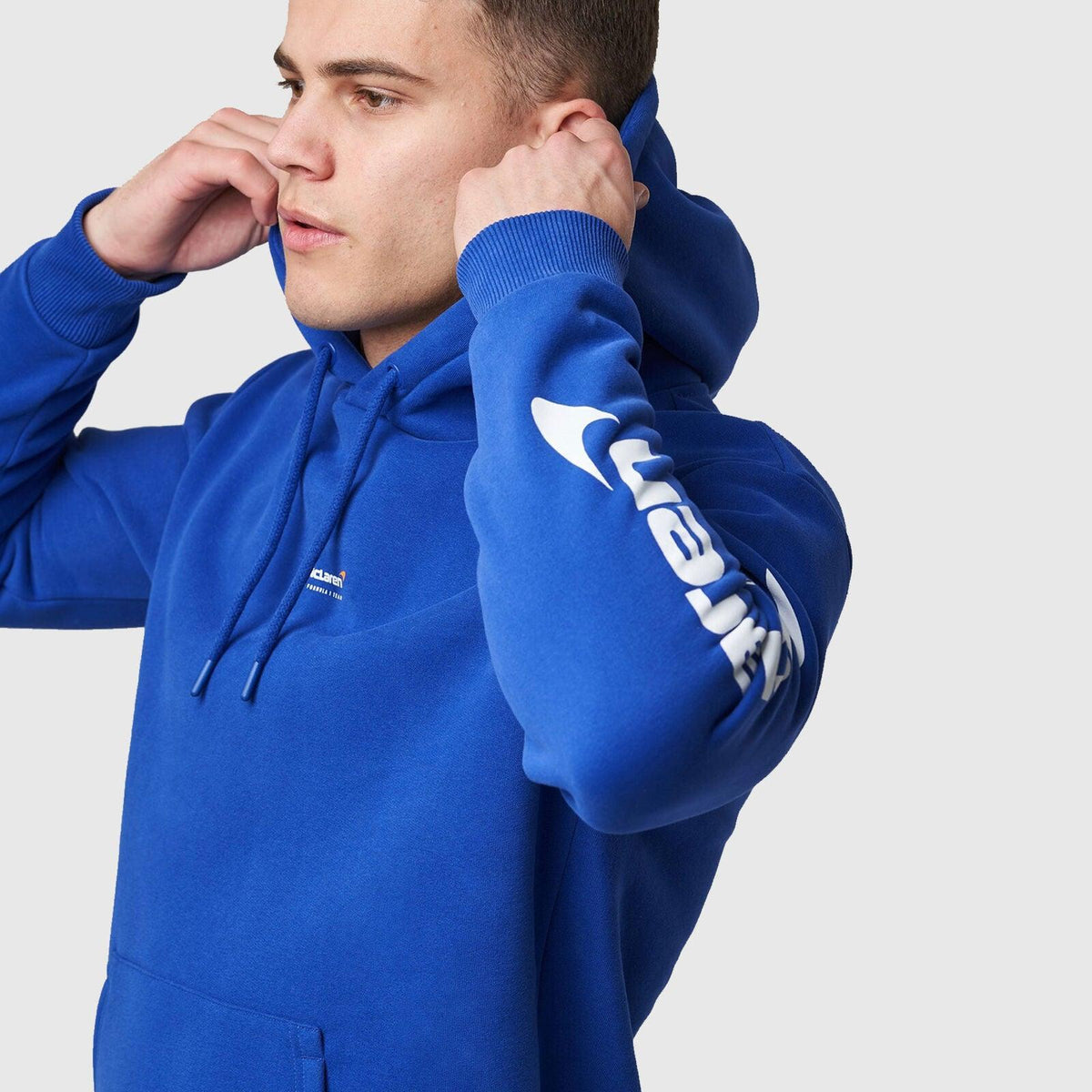 A person wearing a blue McLaren F1 Dynamic Pack logo hoodie.