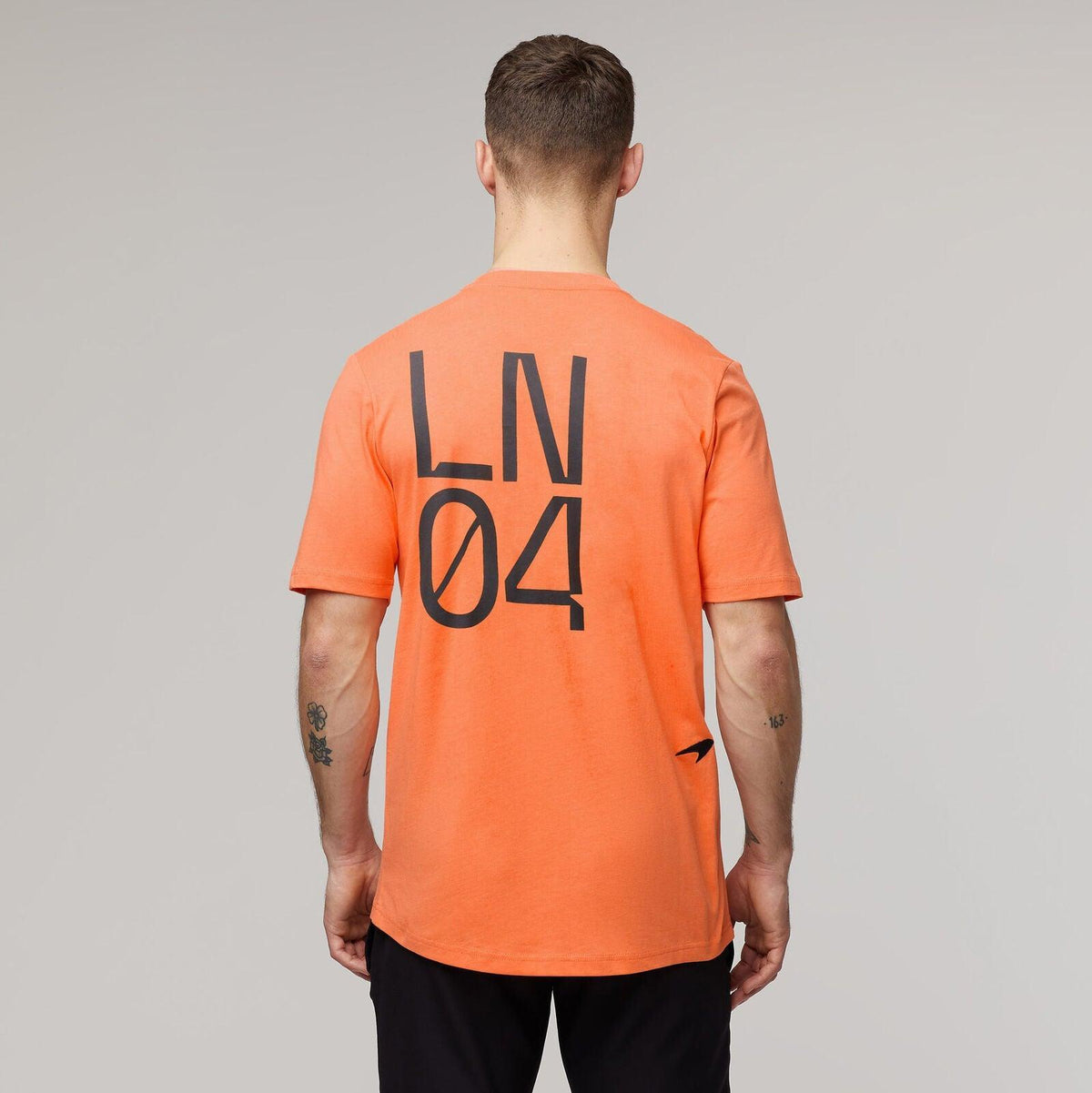 Back view of McLaren F1 Lando Norris Core Essentials orange T-shirt with LN 04 graphic.