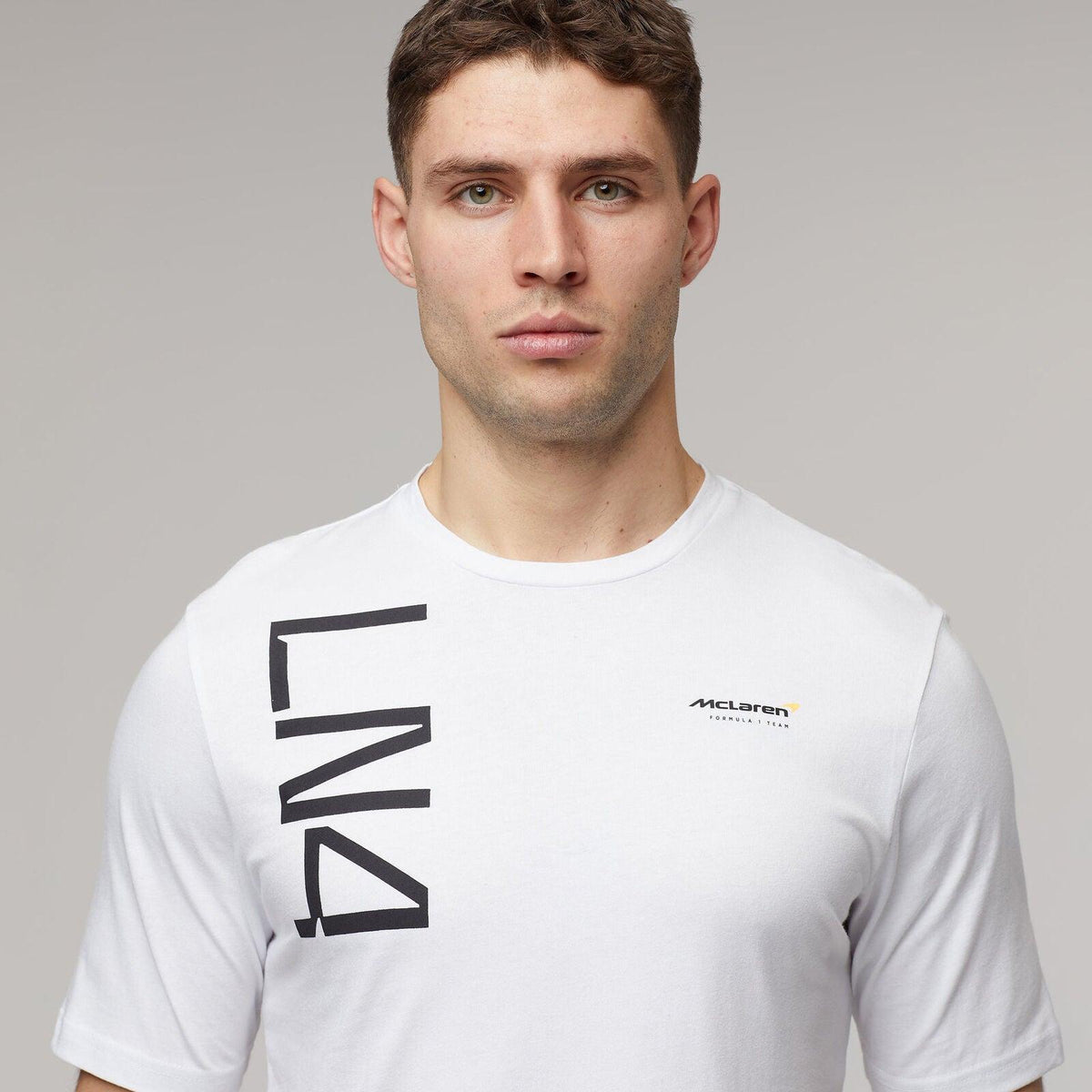 Man wearing a white McLaren F1 Lando Norris Core T-shirt with LN4 graphic.