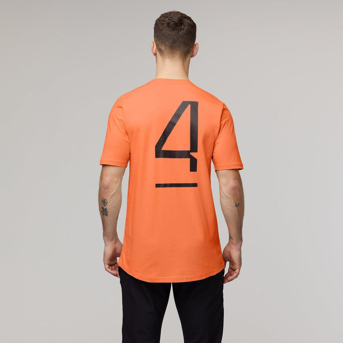Back view of an orange McLaren F1 Lando Norris Core T-shirt featuring a large black number 4.